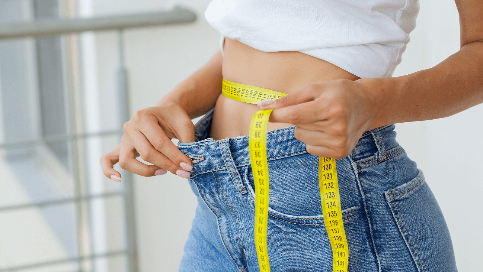 Femme mesurant son tour de taille avec un mètre ruban