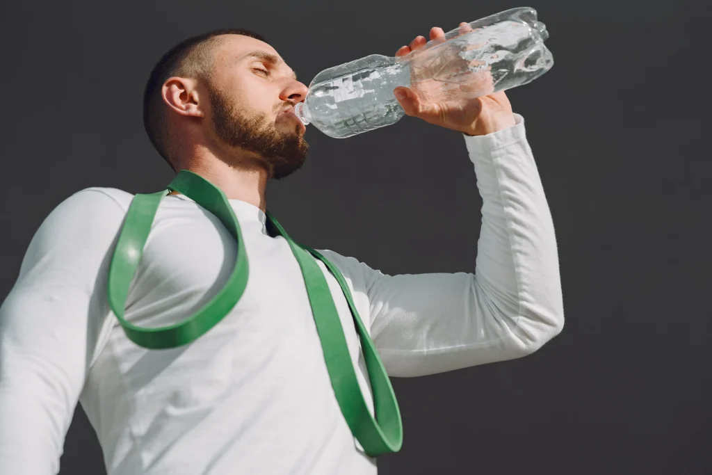 homme qui s'hydrate avec de l'electrolyte pour améliorer son hydratation