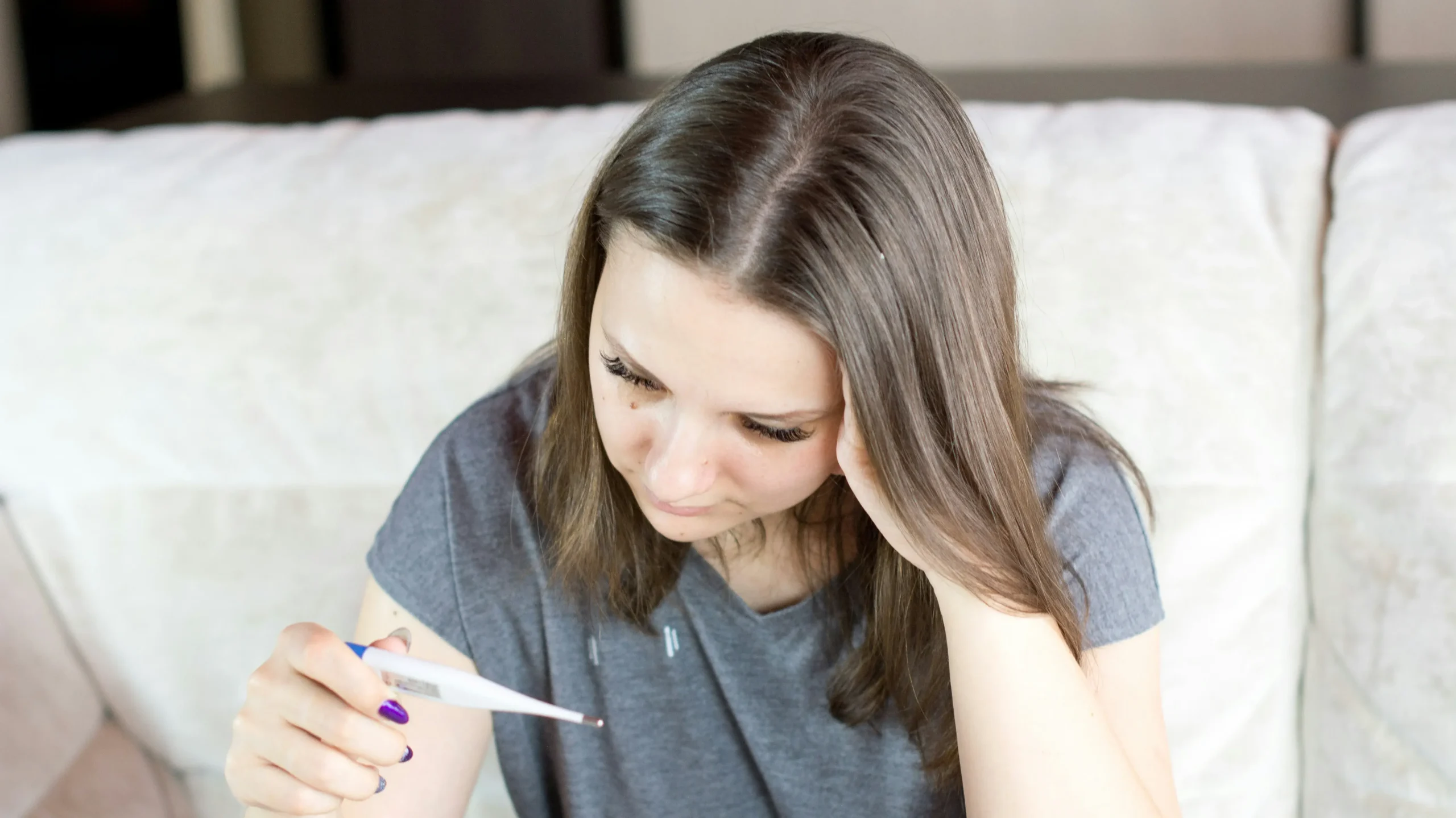 une personne est malade et regarde sa température